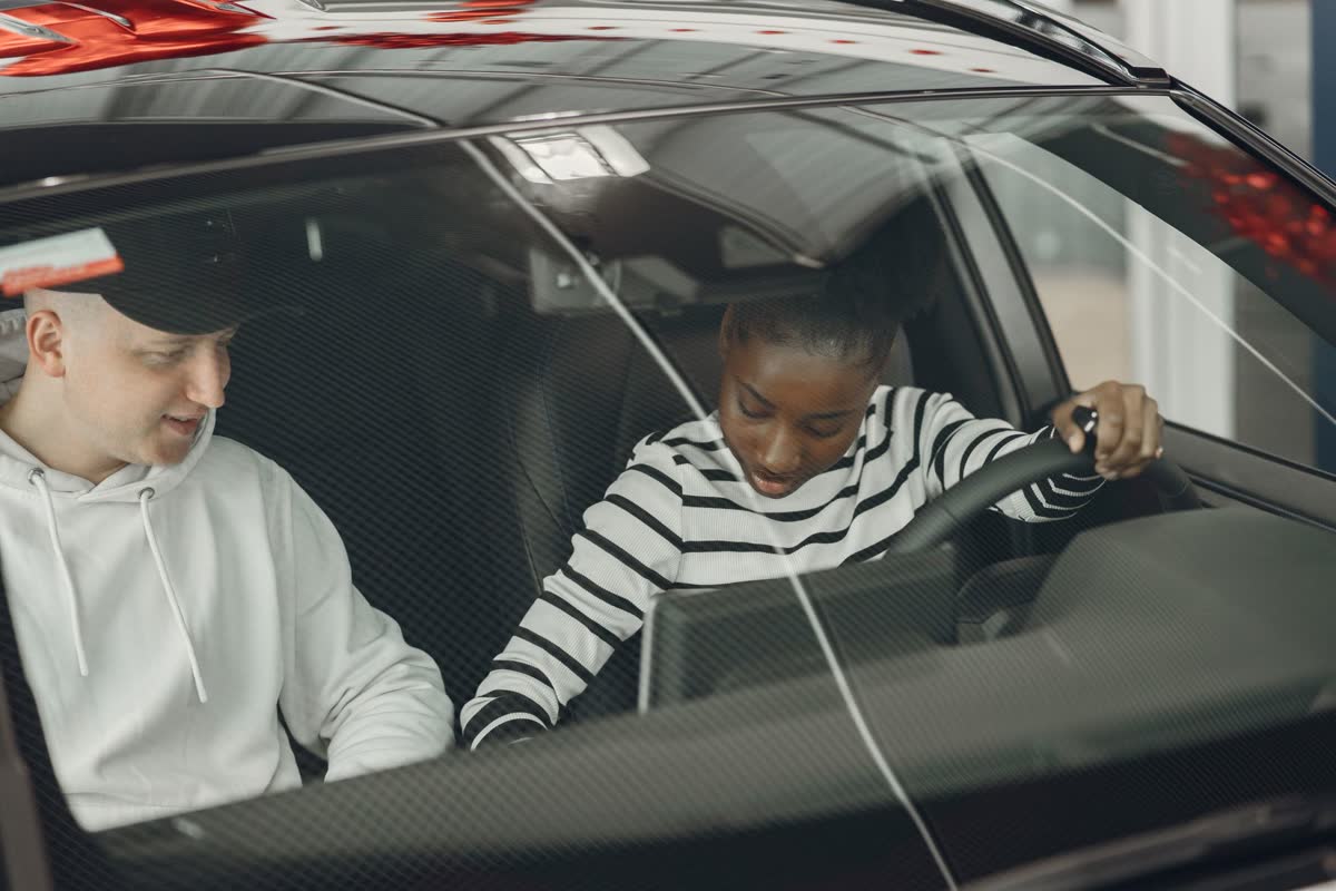 A driving instructor guiding a learner behind the wheel during a lesson