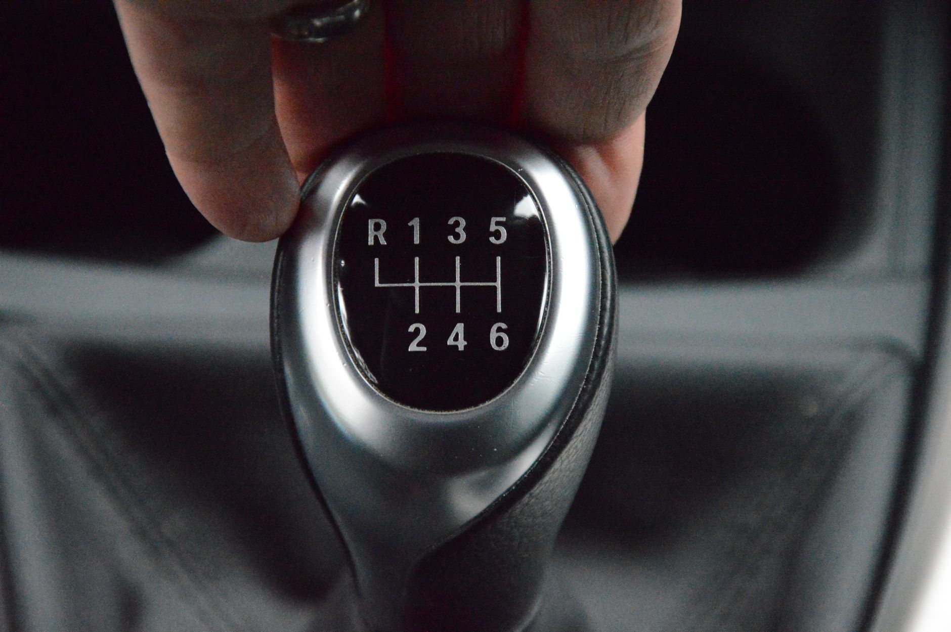 A learner's hand settling onto a manual gear lever for the first time